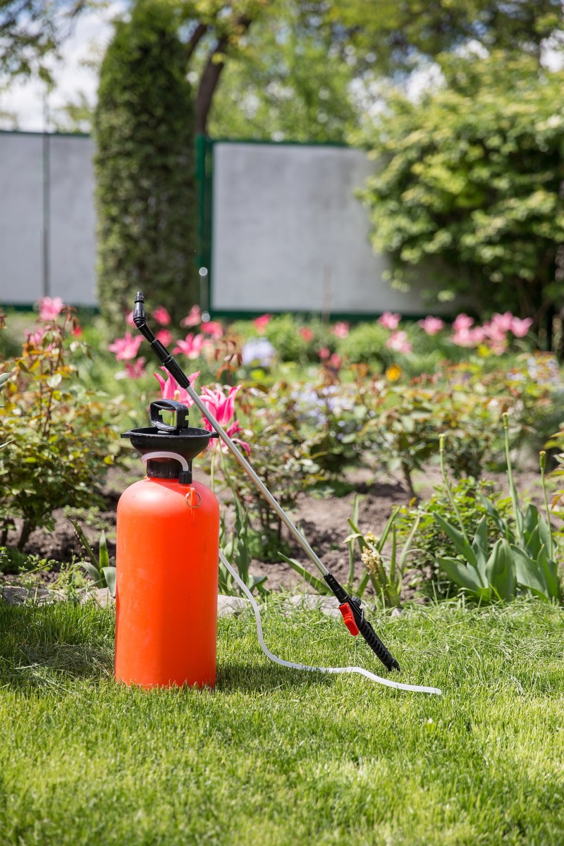 Bote para aplicación foliar de fertilizante naranja en un jardín